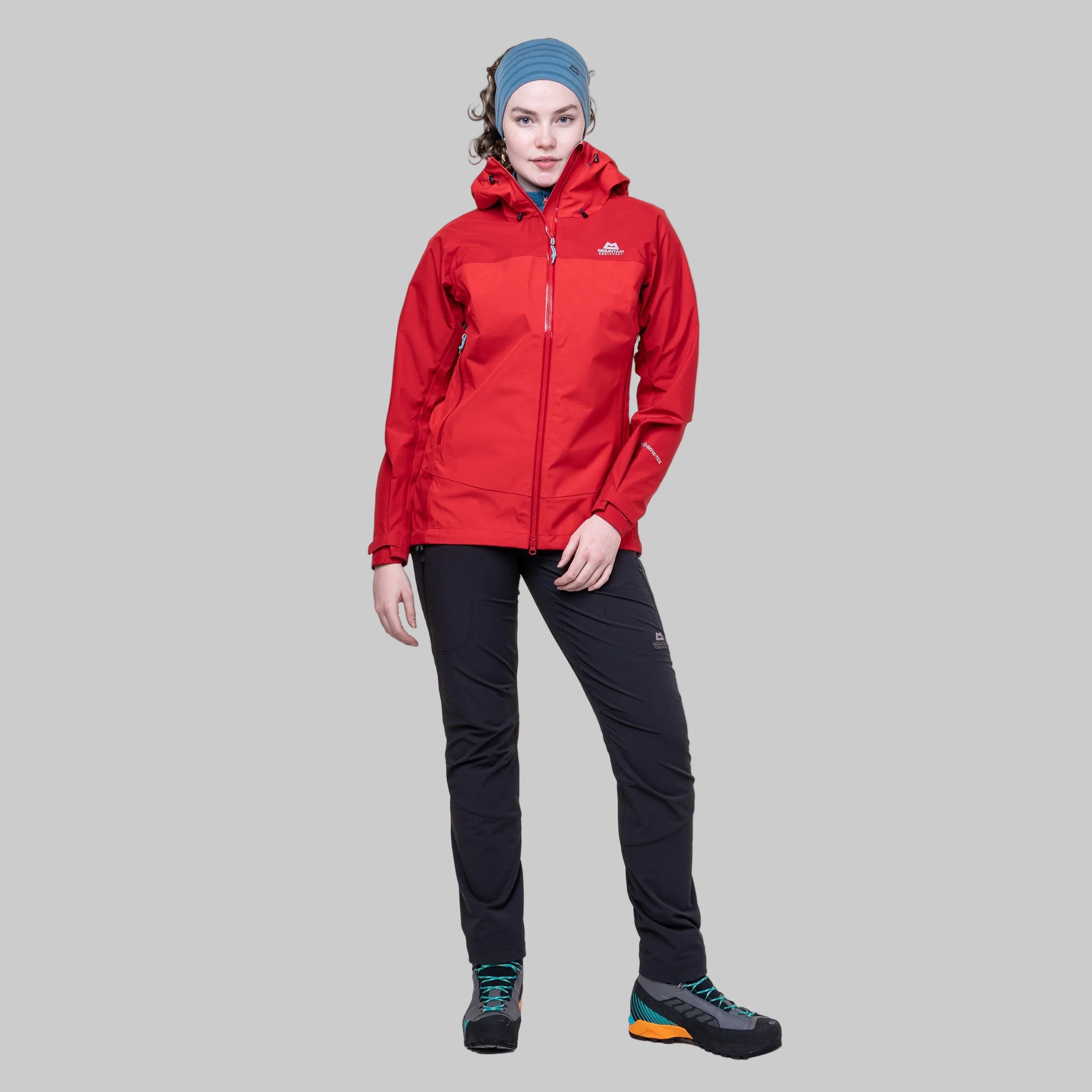 Person wearing a red jacket and black pants on a white background
