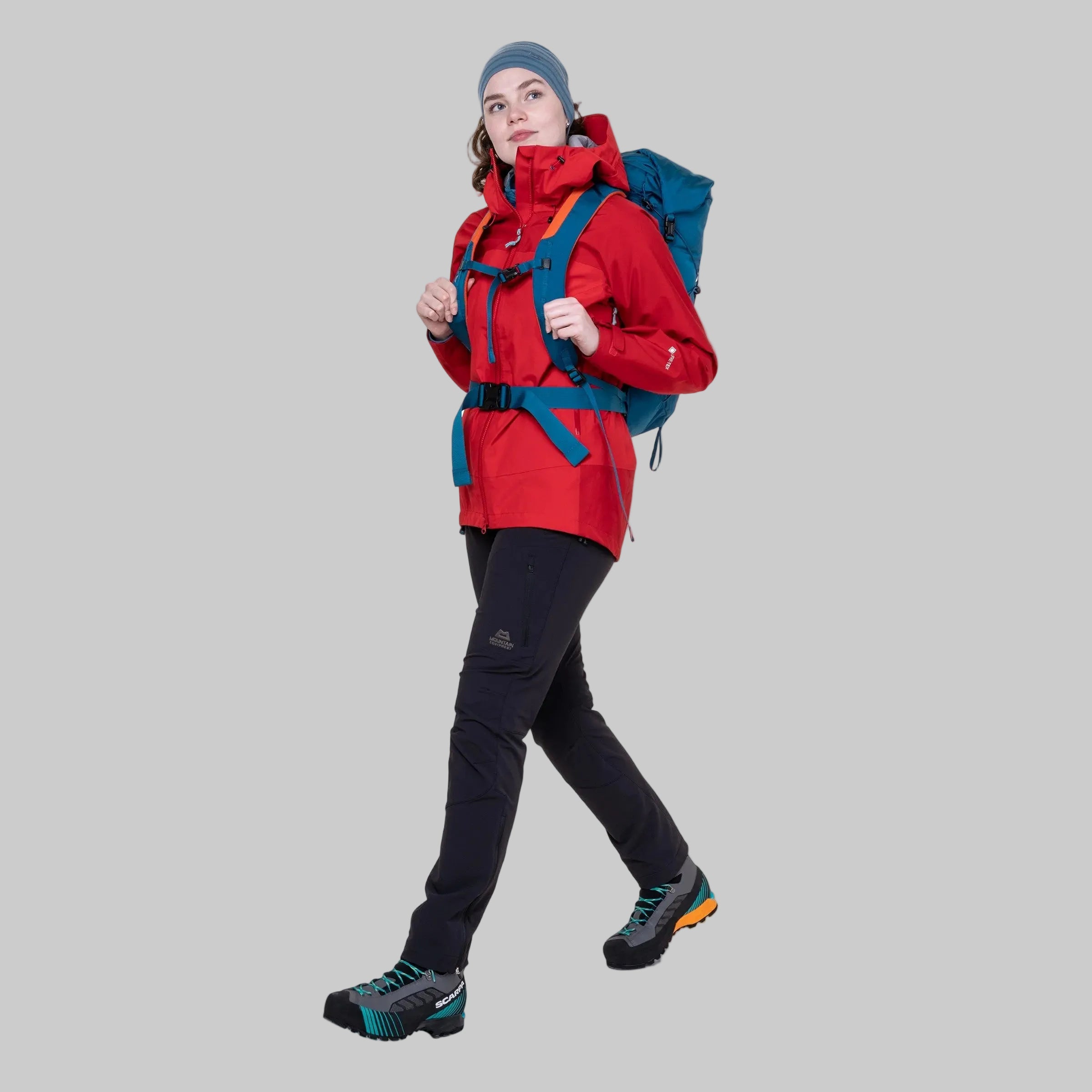 Person wearing a red jacket, black pants, and blue backpack on a white background
