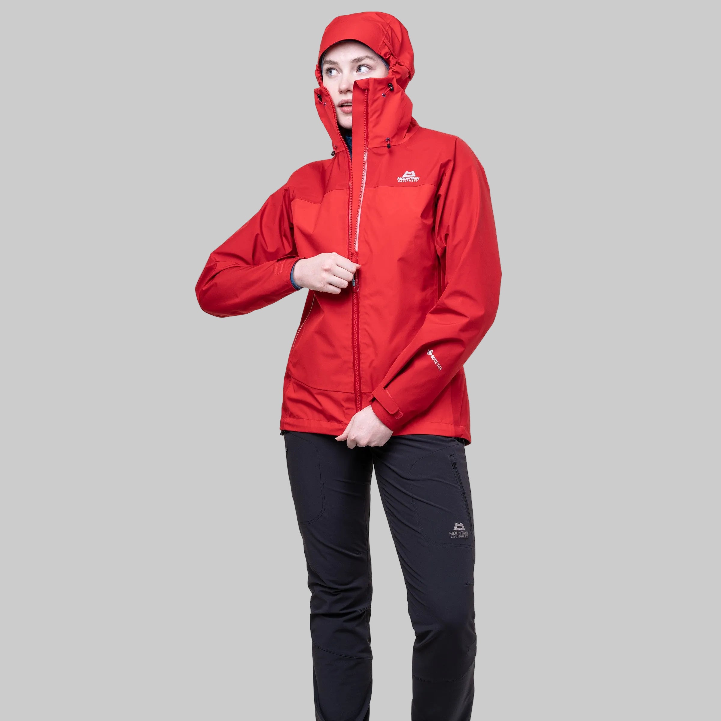 Person wearing a red jacket and black pants on a white background
