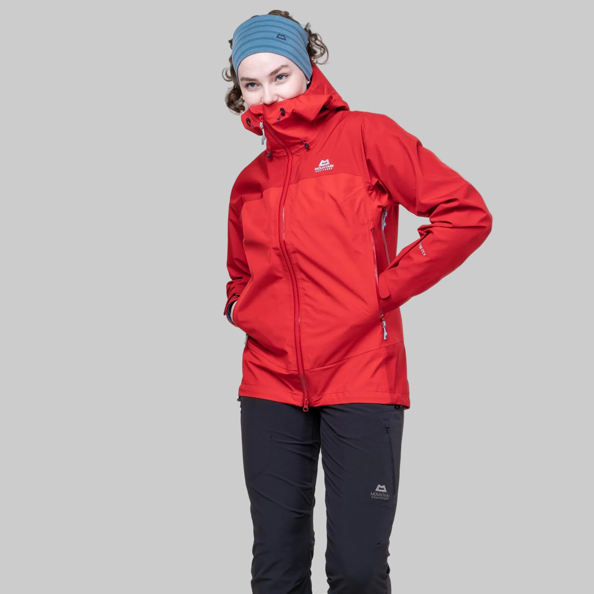 Person wearing a red jacket and black pants on a white background