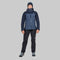 A model wearing a two-tone dark blue and navy hooded technical jacket, black pants, and a dark beanie, standing against a solid white background.